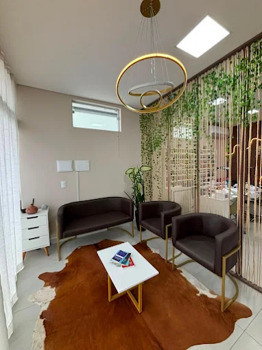 Sala de espera do Espaço Pami Quintino com poltronas marrons e luminária dourada
